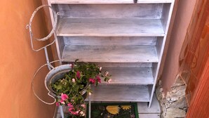 A staircase with a metal handrail, a green mat with cactus and flower designs, and potted plants with pink flowers. - A casa di Oba, vacation home a stone's throw from the sea in Nora, Pula, Sardinia (Pula)