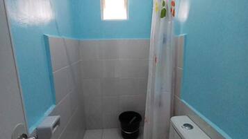 Een kleine badkamer met toilet, wastafel en douchegordijn.
