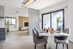 Un comedor moderno con una mesa grande, dos sillas y vistas al exterior.