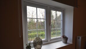 A window with a view of trees and a vase on the sill. - Farmhouse with rural and river views & 10 minute walk to market town (Tenbury Wells)