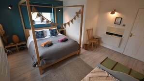 A bedroom with a four-poster bed, a window with a view, a bedside table, a chair, and a door. - Farmhouse with rural and river views & 10 minute walk to market town (Tenbury Wells)