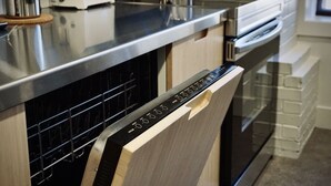Una cucina moderna con elettrodomestici in acciaio inossidabile, lavastoviglie e forno integrato.
