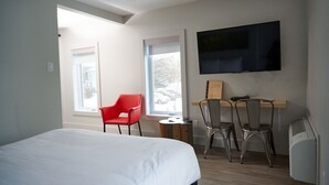 Een hotelkamer met een bed, een bureau met twee stoelen, een flatscreen televisie en een raam met uitzicht.