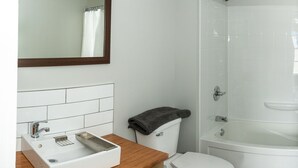 Een badkamer met een witte wastafel, toilet en bad.