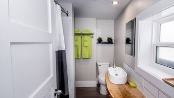 Une salle de bain moderne équipée de toilettes, d’un lavabo et d’une zone douche.