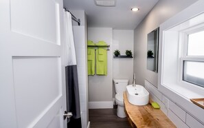 Een moderne badkamer met toilet, wastafel en douche.