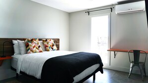 Una habitación de hotel moderna con una cama grande, un escritorio con silla y una ventana con vistas.