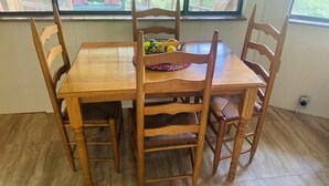 A wooden dining table with four chairs, a fruit bowl, and a window with a view of greenery. - Roundhouse Cabin in Pigeon Forge …in town  (Pigeon Forge)