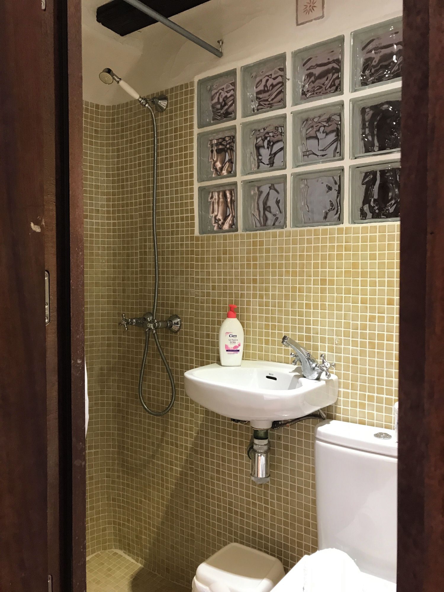 Un baño con ducha, lavamanos e inodoro.