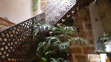 A staircase with a black metal railing and potted plants.