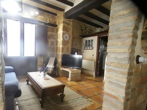 Ein Wohnzimmer mit einer Couch, einem Couchtisch, einem Fernseher und einem Kamin.