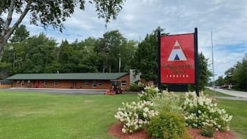 A building with a red roof and a sign with a white 'A' logo.