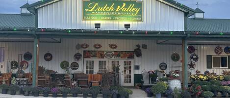 A Dutch Valley store with a signboard, potted plants, and outdoor seating.