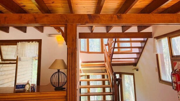 Techo de madera con una escalera que sube a un nivel superior.