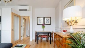 Una sala moderna con una mesa de comedor de madera, un sofá y un mueble con una lámpara.