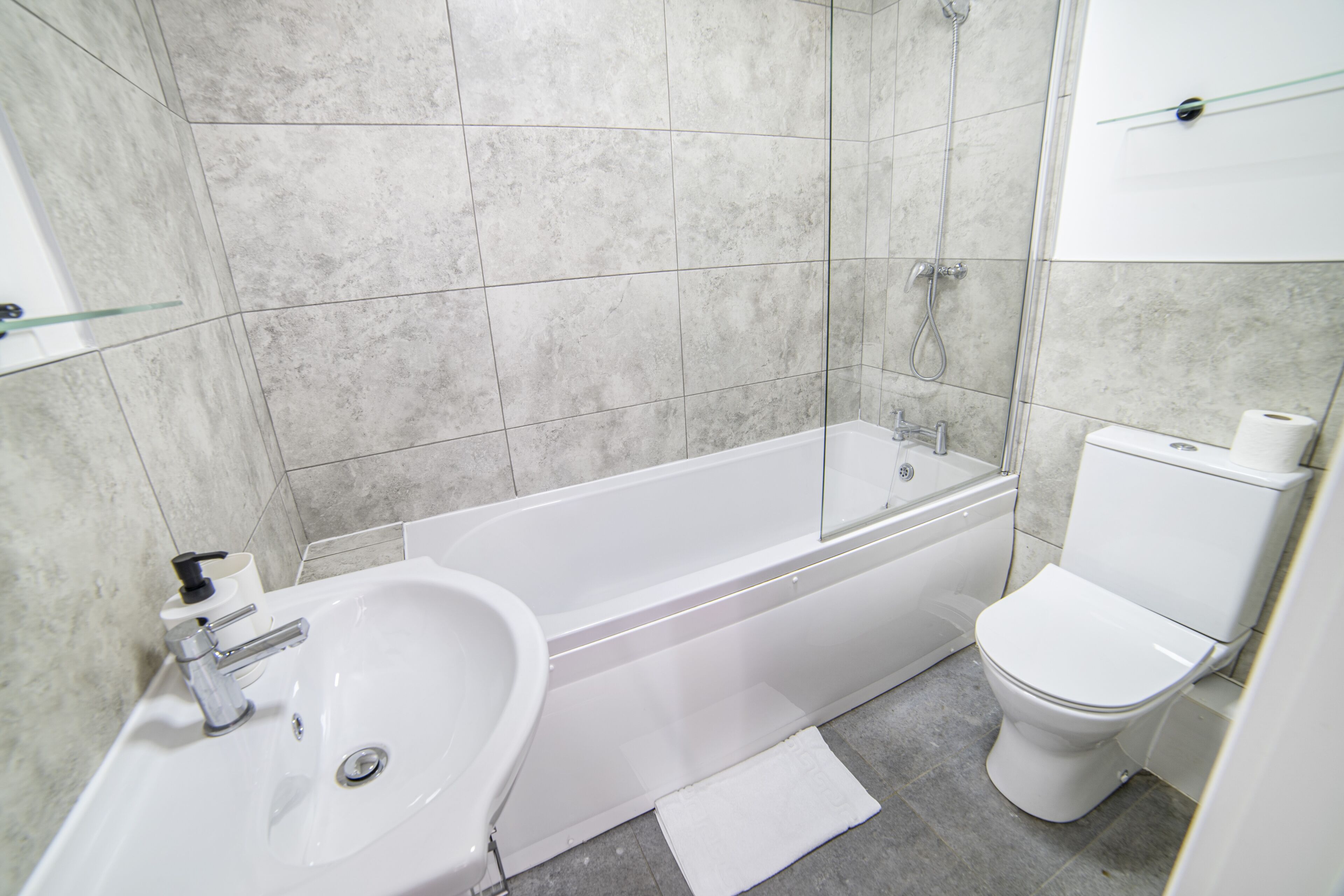 Et moderne badeværelse med badekar, vask og toilet.