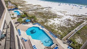 Un hotel con una piscina grande, acceso a la playa y vistas al océano.