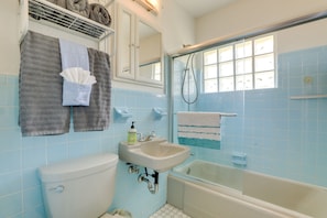 A bathroom with a toilet, sink, and bathtub. There are towels hanging on the wall and a shower curtain. - Pet-Friendly Port Charlotte Home w/ Canal Access! (Port Charlotte)