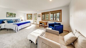 A spacious bedroom with a large bed, a sofa, and a small table. - Serene La Conner Retreat w/ Fireplace & Deck! (La Conner)
