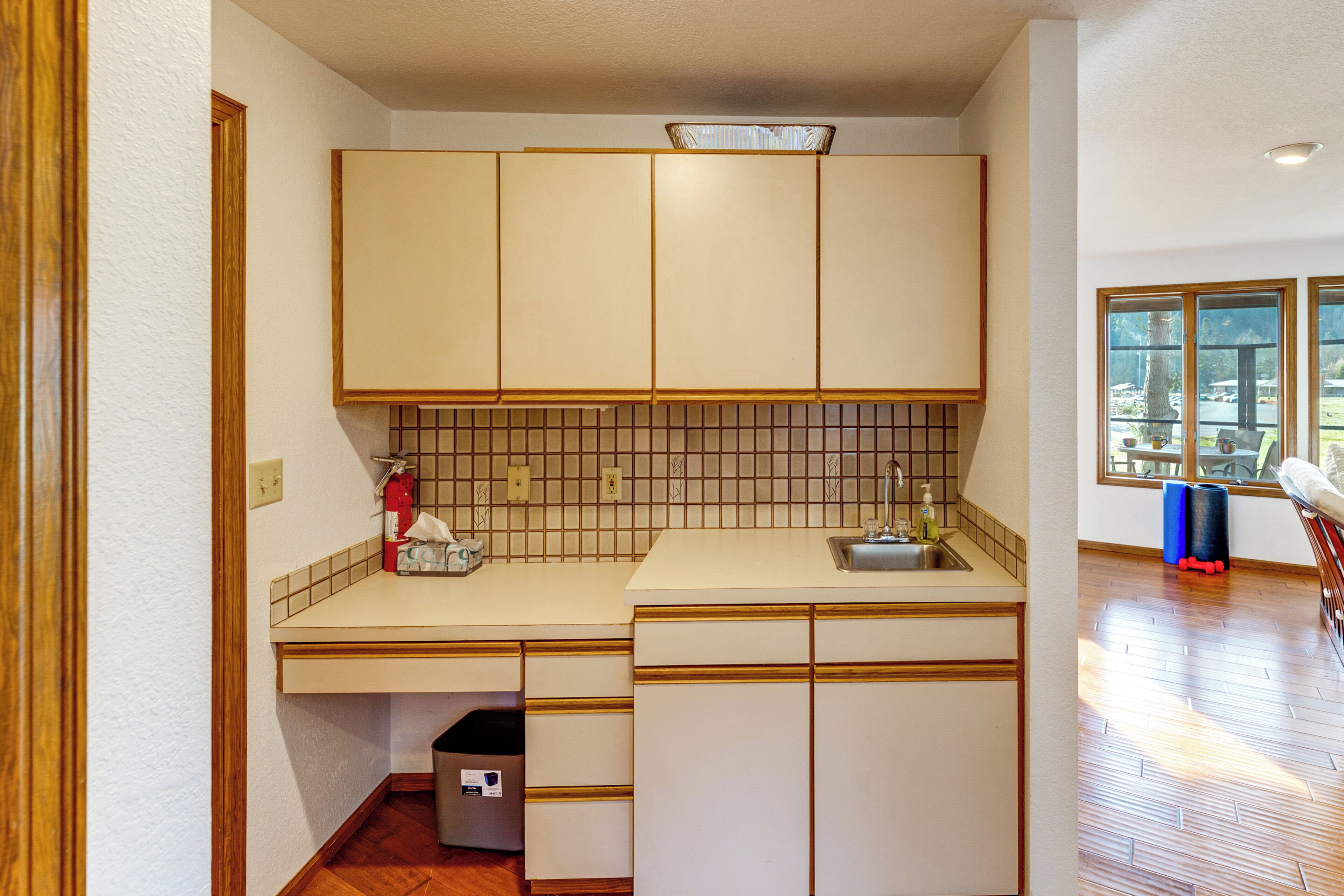 A compact kitchen with a sink, countertop, and cabinets.