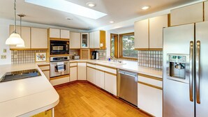 A modern kitchen with a dishwasher, oven, microwave, and a built-in water dispenser. - Serene La Conner Retreat w/ Fireplace & Deck! (La Conner)