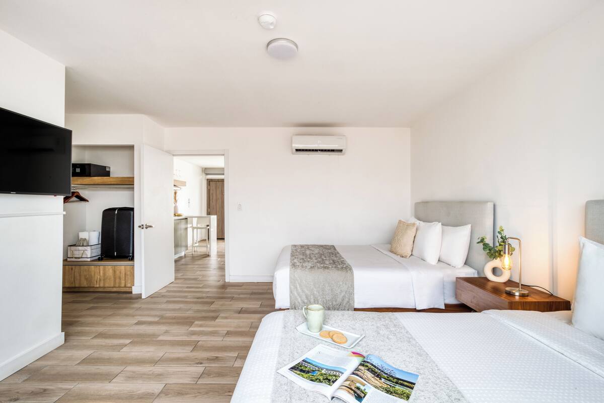A modern hotel room with a bed, bedside table, and a TV.