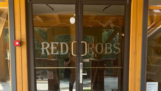 A wooden building with a glass door entrance labeled "RED ROBS". - Red Rob #6 - 2 bedroom Sleeps 6 (Rossland)