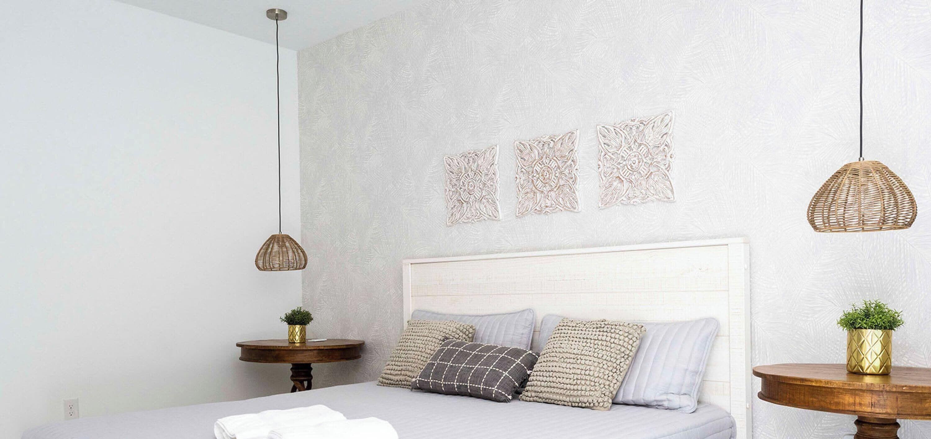 Een slaapkamer met een bed, nachtkastjes en decoratieve wandkunst.