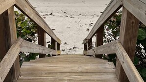 A wooden staircase leading to a beach with waves. - Gorgeous 8B 7BA Melbournbeach w Pool Dock Beach (Melbourne Beach)