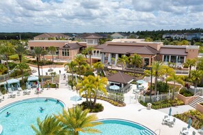 A resort with a swimming pool, lounge areas, and multiple buildings with a uniform architectural style.