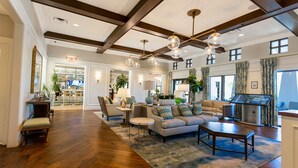 A spacious lobby with wooden flooring, a central seating area with sofas and chairs, a reception desk, and large windows allowing natural light. - Fabulous 9BD 6BA Starwarsgamer Sleep22 Solarareso (Kissimmee)