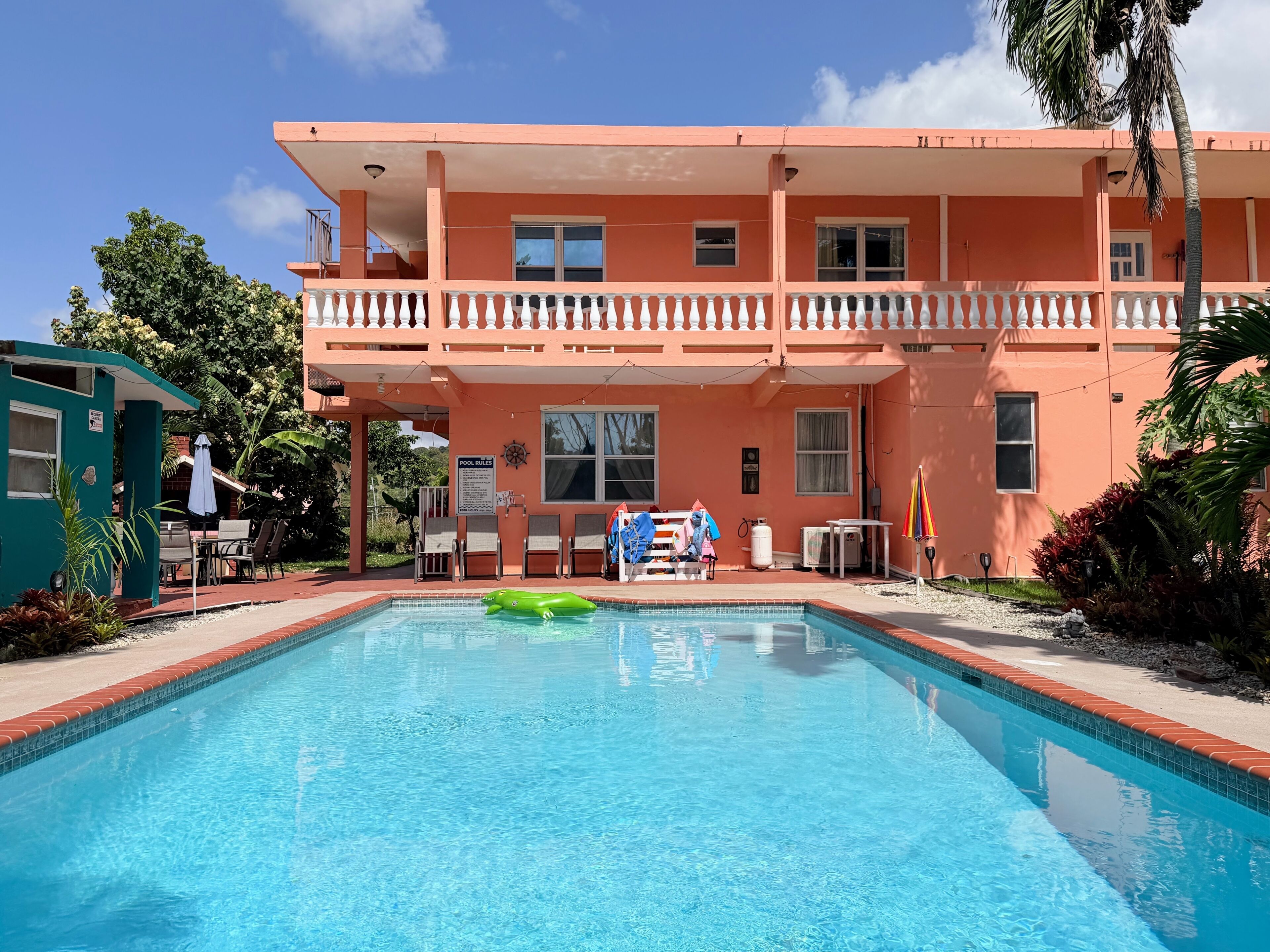 Un edificio de dos pisos con piscina delantera.