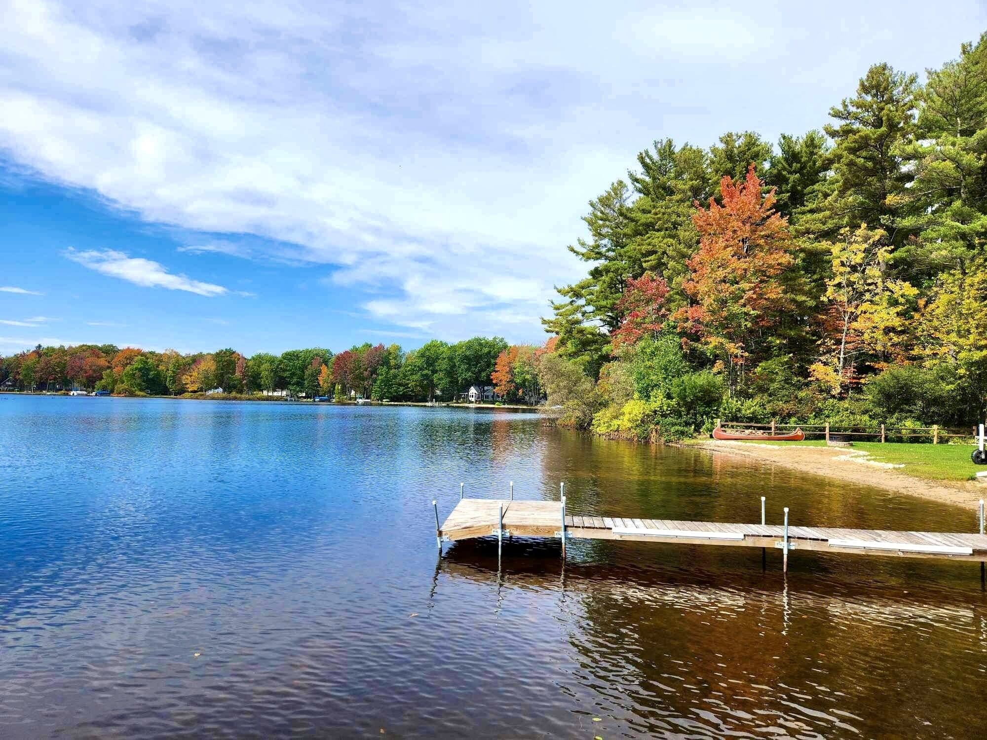 A calm lake with a wooden dock extending into the water.