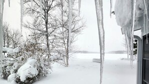 A snowy landscape with icicles hanging from a building's exterior. - Cozy Private Lakefront Cottage, Pet-Friendly with Private Dock (Kalkaska)