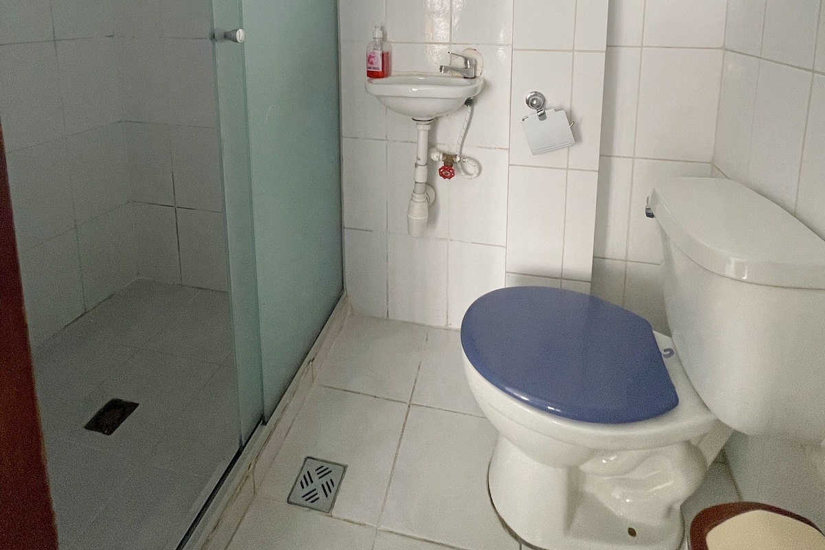 A bathroom with a toilet, sink, and shower.