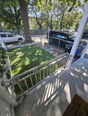 Relax in an outdoor space with a lush lawn and metal railing.