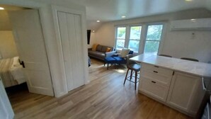 A spacious kitchen with a dining area, a sofa, and a window providing natural light.
