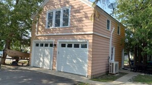 A two-story house with a garage and a satellite dish.