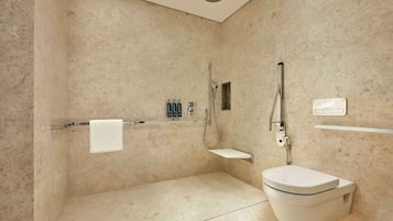 Een moderne badkamer met douche, toilet en wastafel.