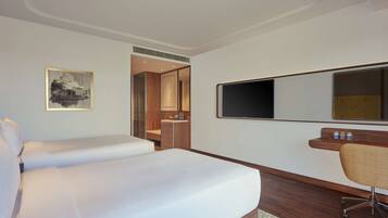 Relax in a spacious room with a large bed, flat-screen TV, and a comfortable workspace.