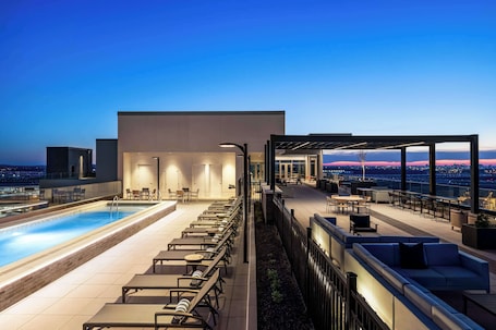 Una piscina al aire libre, sillones reclinables de piscina