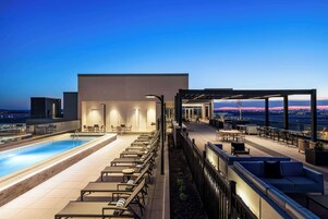 Una piscina al aire libre, sillones reclinables de piscina