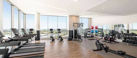 A spacious gym with treadmills, exercise bikes, and weight machines.