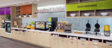 A breakfast area with a 'Good Morning' sign, a 'Inspired Table' sign, and various breakfast items on display.