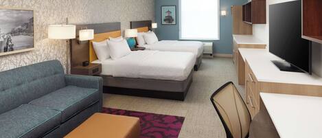A hotel room with two beds, a sofa, a desk, and a TV.