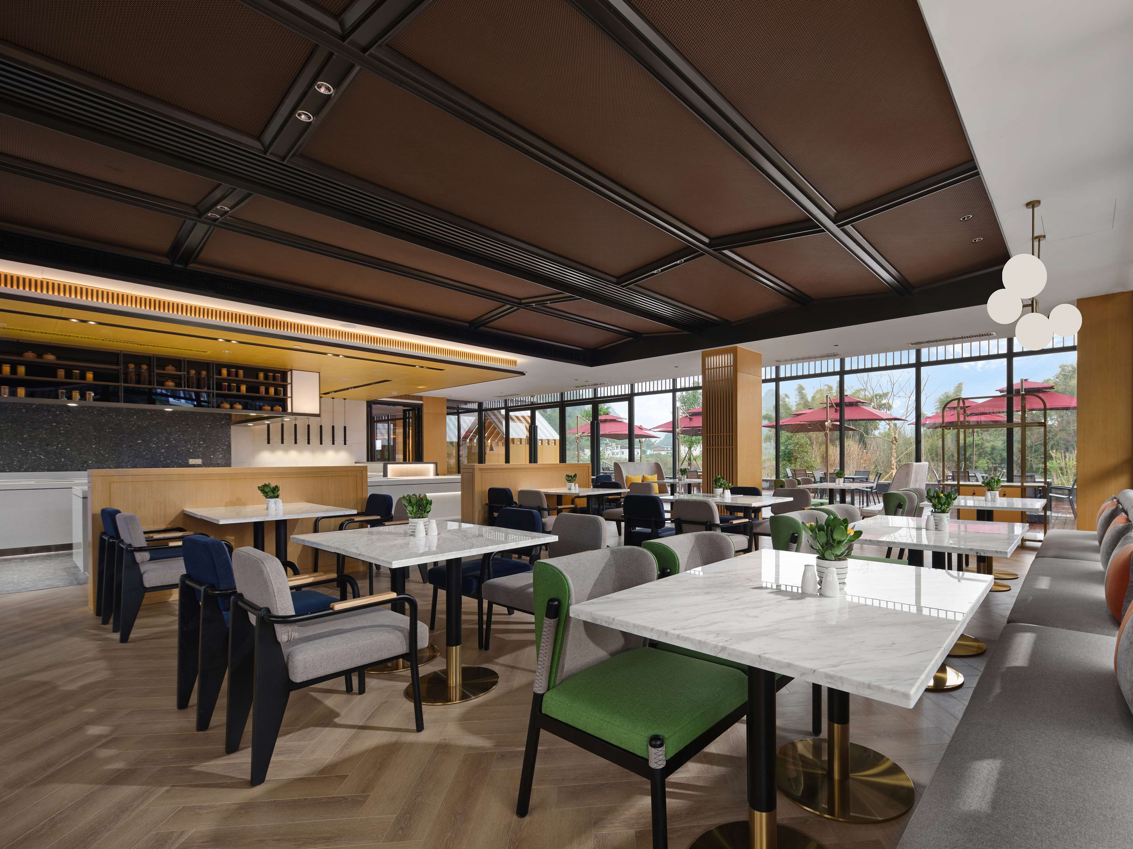 A modern restaurant with high ceilings, large windows, and a variety of seating arrangements including tables and booths.