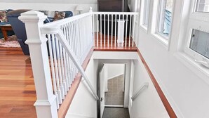 Una escalera con barandillas blancas y escalones de madera que conducen a una plataforma.