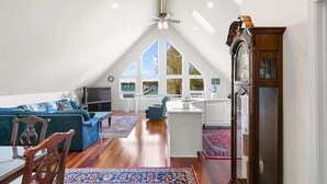 Un loft espacioso con techo alto, comedor, cocina y un ventanal con vistas al exterior.