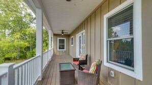 A covered porch with wicker furniture, a ceiling fan, and large windows. - Secluded Barboursville Home with Covered Porch! (Barboursville)
