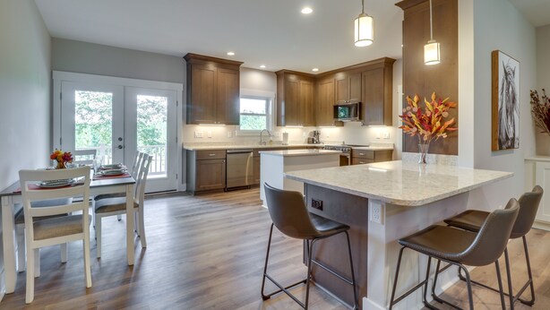 A modern kitchen with a large island, wooden cabinets, and pendant lighting. - Secluded Barboursville Home with Covered Porch! (Barboursville)